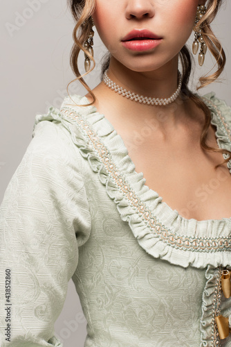 cropped view of young woman in vintage dress posing isolated on grey