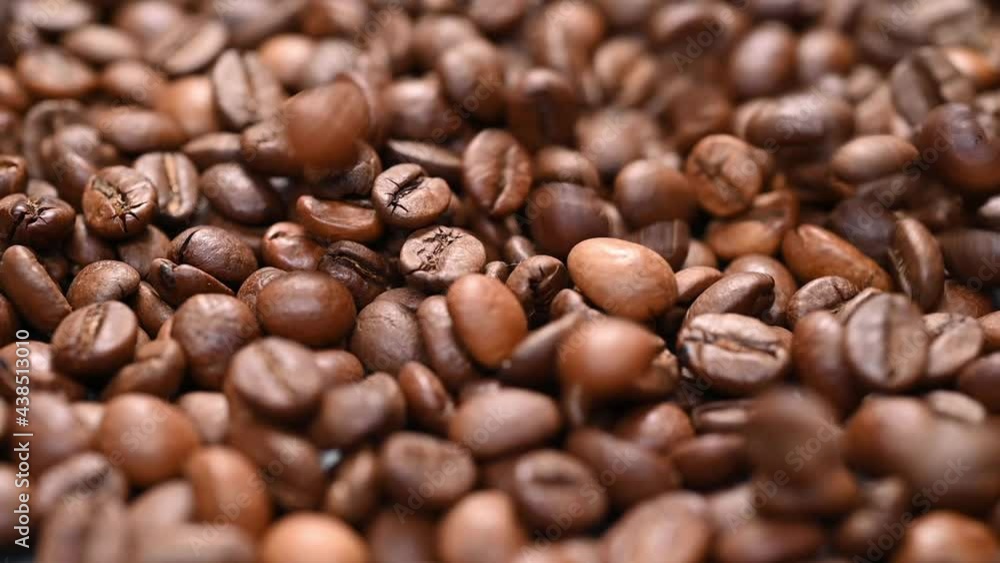 Roasted Arabica beans fall on the table, slow motion. Detailed close-up. Roasted Arabica beans fall on the table, slow motion. Detailed close-up.