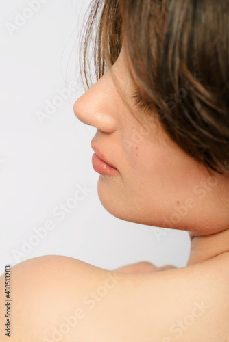 Close up shot  of a woman's cheek with short hair.