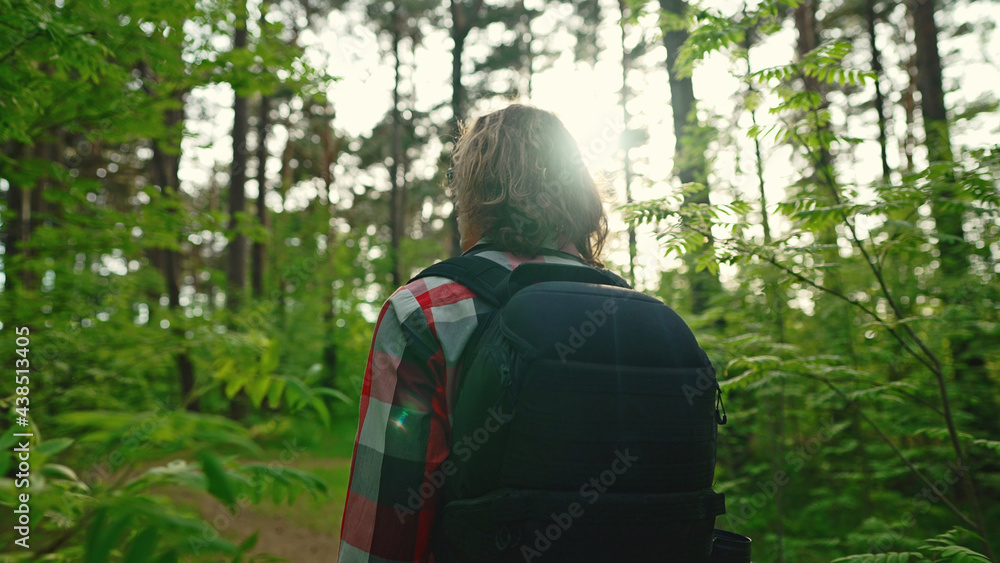 Man with backpack and sunglasses in the woods. Arc shoot.