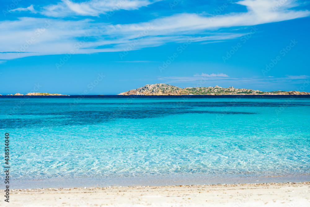 Stunning view of a turquoise sea whit a small island in the distance. Romazzino Beach, Costa Smeralda, Sardinia, Italy. Natural background with copy space.