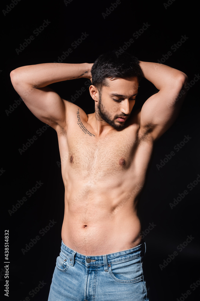 Shirtless and bearded man posing isolated on black
