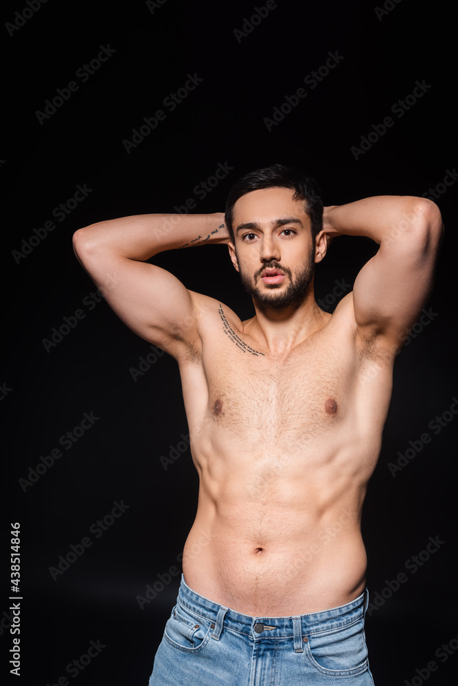Fototapeta premium Muscular man looking at camera isolated on black