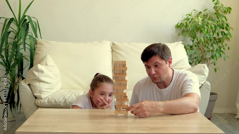 Happy family, Father and daughter excites with wooden block game at home, selective focus Happy family, Father and daughter excites with wooden block game at home, selective focus