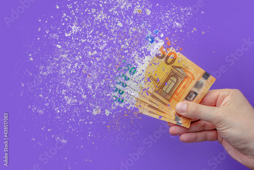 inflation euro . Inflation in Europe, hyper inflation. Banner with purple background. Fifty euro banknotes sprayed in the hand of a man on a purple background. photo