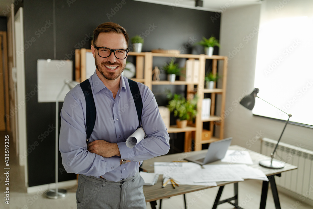Portrait of young architect looking at camera in office. Portrait of young architect looking at camera in office.