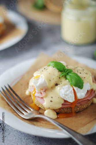Egg benedict sandwiches - muffin with poached egg, ham and hollandaise sauce