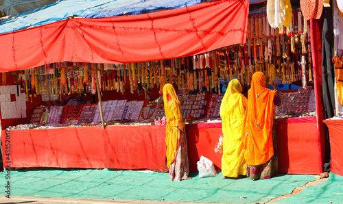Obraz na płótnie Pushkar, India - November 10, 2016: Bunch of women in traditional hindu wear saree buying or shopping jewelery items in the commercial street of Pushkar fair in the state of Rajasthan w salonie