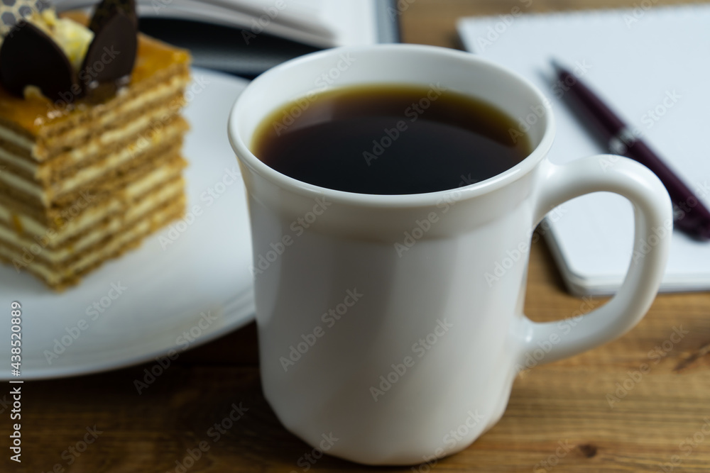 Cup of coffee close up and cake on the plate on wooden table. Concept coffee break and relaxation. Cup of coffee close up and cake on the plate on wooden table. Concept coffee break and relaxation.