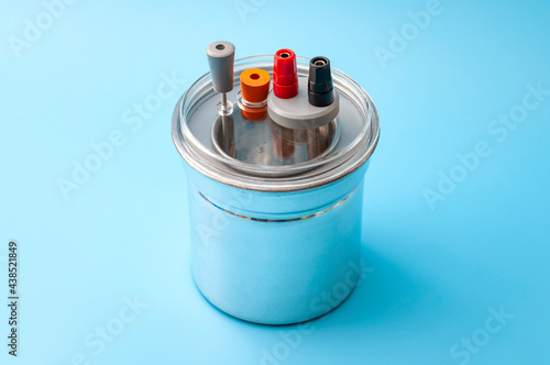 Thermodynamics, calorimetry test and scientific measuring of heat capacity concept with metal calorimeter isolated on blue background photo