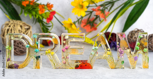 Decoration word dream with colorful bright flowers epoxy resin photo