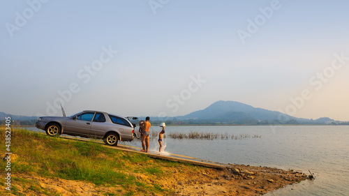 CHONBURI,THAILAND - February11, 2018 : Happy asian family washing a car and take a shower in the lake photo