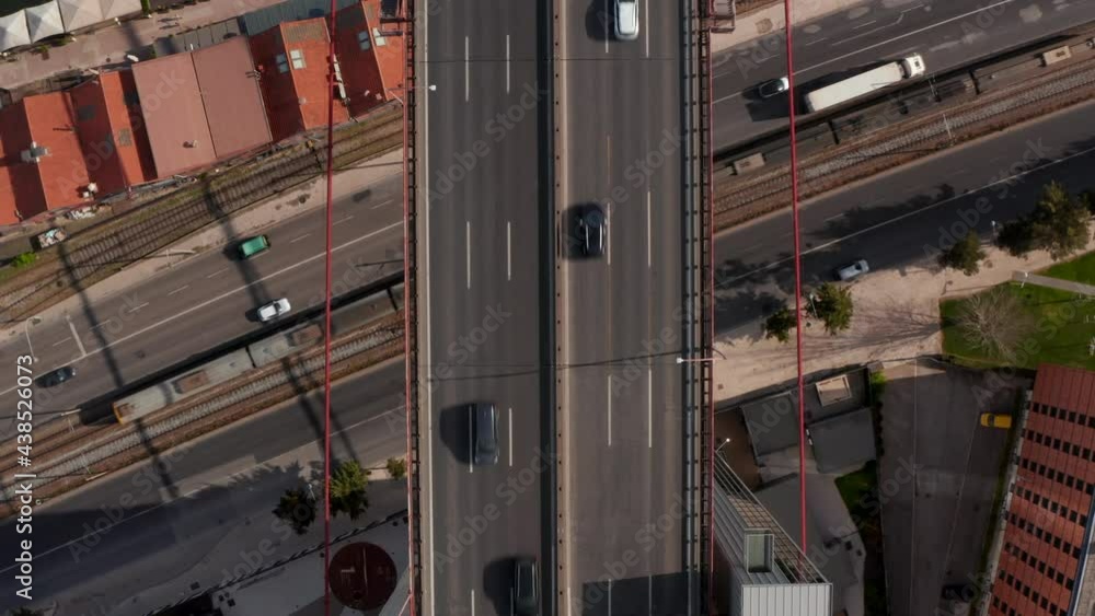 Aerial birds eye overhead top down view of traffic on highway bridge leading over street and railway track. Zooming out footage from drone. Lisbon, capital of Portugal. Aerial birds eye overhead top down view of traffic on highway bridge leading over street and railway track. Zooming out footage from drone. Lisbon, capital of Portugal.