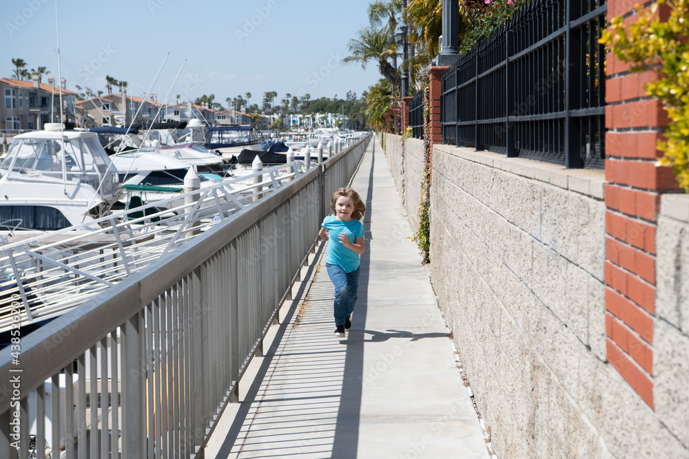 Active boy kid enjoy summer holidays running on promenade, fun Active boy kid enjoy summer holidays running on promenade, fun