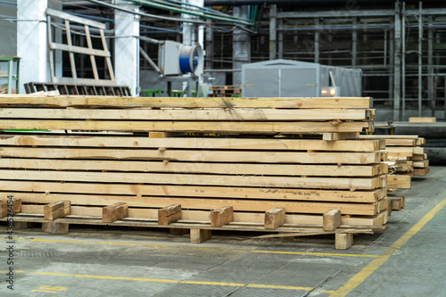 Stack of wooden boards in woodworking factory. Timber for construction industry.