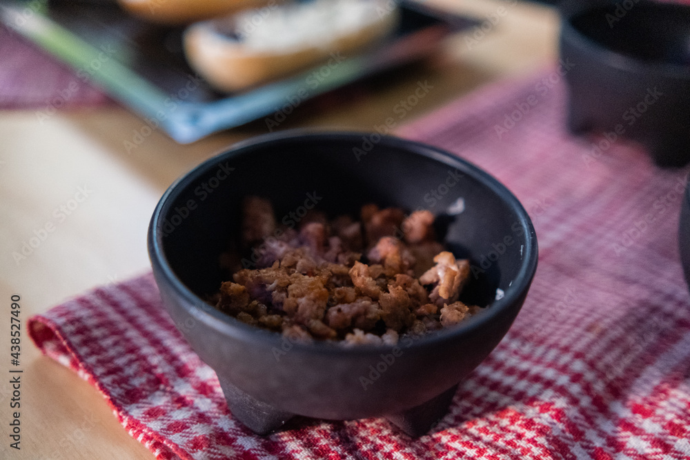 Chopped pork in black bowl above checkered napkin Chopped pork in black bowl above checkered napkin