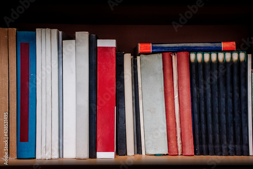 Row of books on a shelf with no titles or markings of any kind