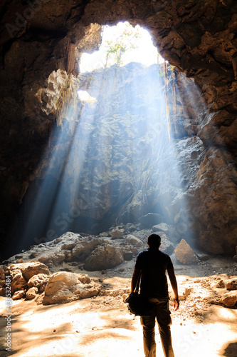 Beautiful sunbeam with the man in a cave