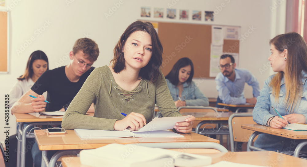 Fototapeta premium Girl is writing test and answer about task in the classroom.