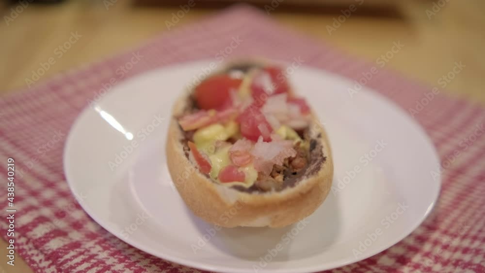 Traditional Mexican mollete on a plate above white and red checkered napkin Traditional Mexican mollete on a plate above white and red checkered napkin