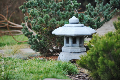 Japanese-style stone lantern among various plants in the botanical garden © Vladimir