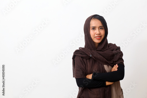 A portrait of happy asian muslim woman wearing a veil or hijab smiling and looking at the camera. Isolated on white background with copy space © SetianingDyah