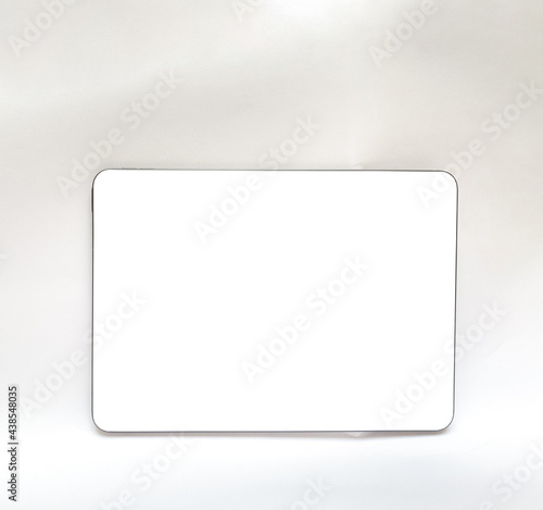The tablet is black on a white isolated background with a mock up. Back side view of the tablet