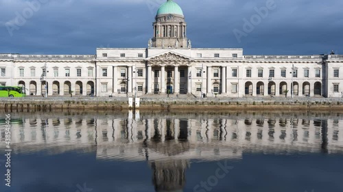 Time lapse of Custom House historical building in Dublin City during daytime with reflection on Liffey river in Ireland. photo