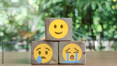 best excellent business services rating customer experience. Satisfaction survey concept. Hand of a woman chooses a smiley face on wood block cube. photo