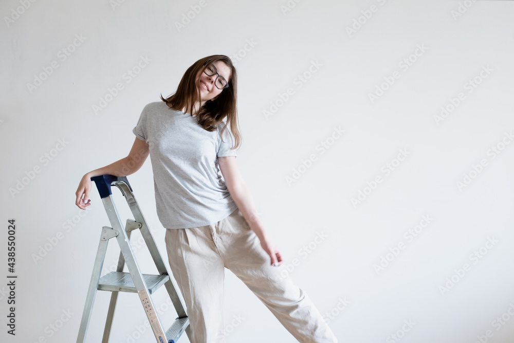 Joyful smiling girl on a stepladder. Repair ladder. Joyful smiling girl on a stepladder. Repair ladder.
