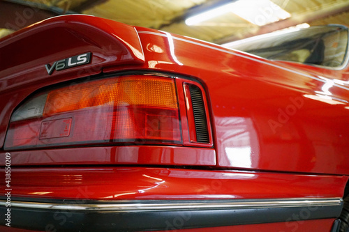 rear left headlight of a red car with a V6 LS plate close-up © ALEKSANDR SEMENOV