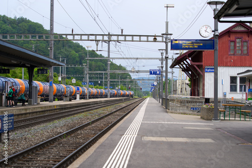 Empty platform at railway station Eglisau, canton Zurich, at summertime with cargo train. Photo taken June 9th, 2021, Eglisau, Switzerland.
