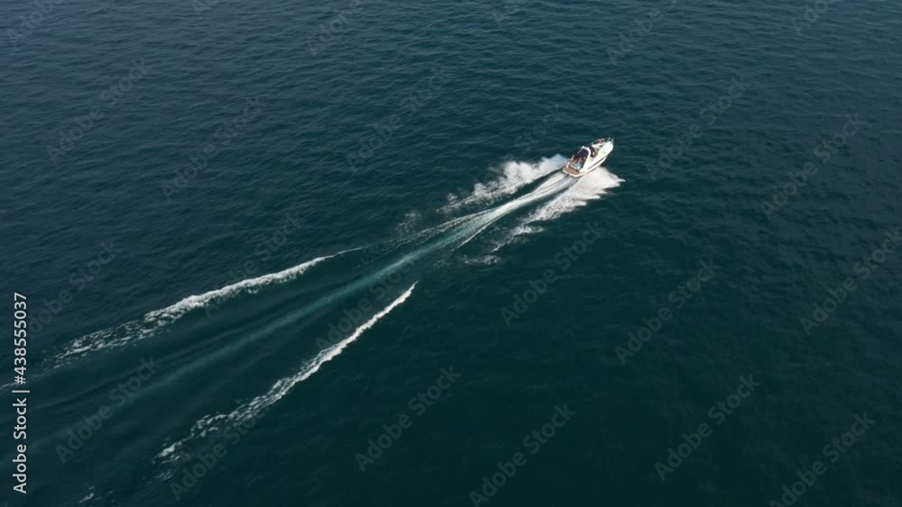 White large yacht at high speed in the sun. Aerial view. People on the boat	