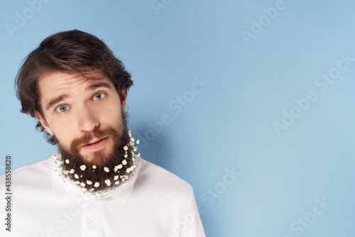 Cheerful bearded man with flowers in his hair modern style