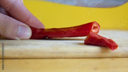 Cutting Red Pepper with a knife. Red pepper is great spice for health, you can add it to your food or make drinks with it photo