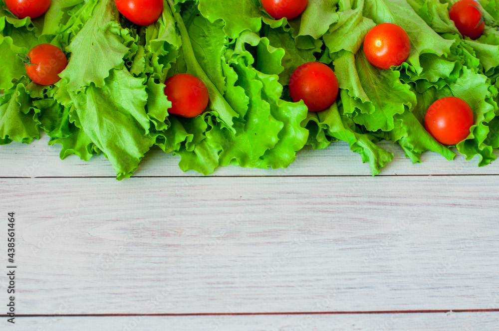 fresh lettuce and cherry tomatoes on a light wooden background. High quality photo fresh lettuce and cherry tomatoes on a light wooden background. High quality photo