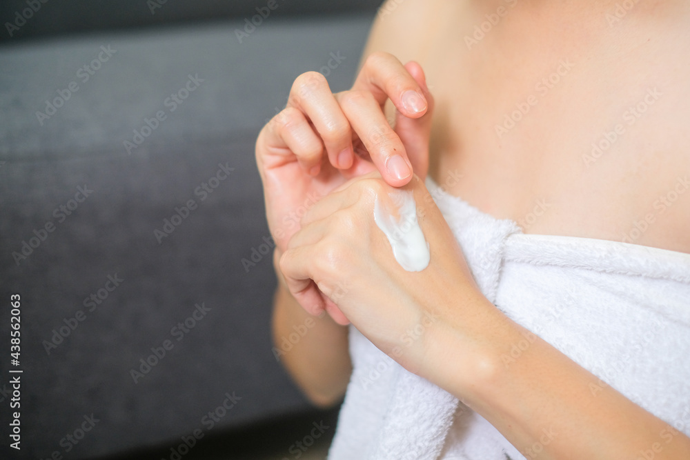 Naklejka premium Woman applying natural cream, Woman moisturizing her hand with cosmetic cream, Spa and Manicure concept.