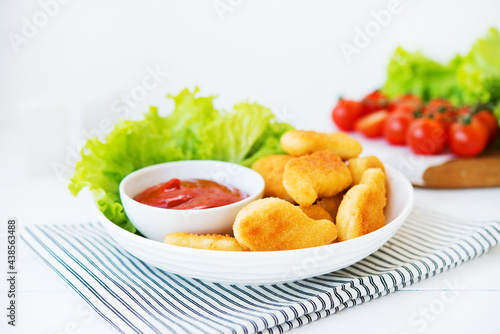 Chicken nuggets with sauce and herbs in a plate