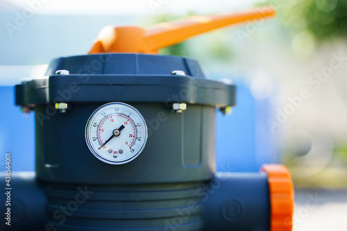 Pressure gauge measuring water pressure in a sand pump of an outdoor pool filtration system