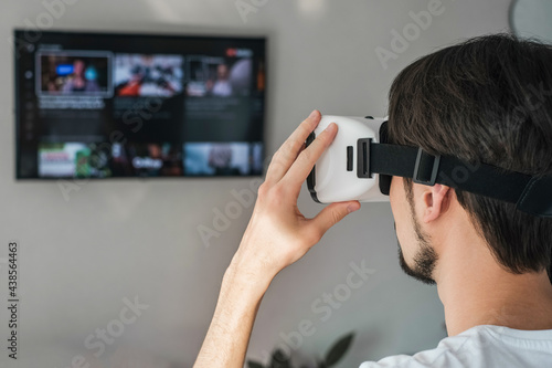 a young man plays a virtual game in VR glasses. home leisure on self-isolation at home. The virtual reality. portrait of handsome young man wearing virtual reality glasses