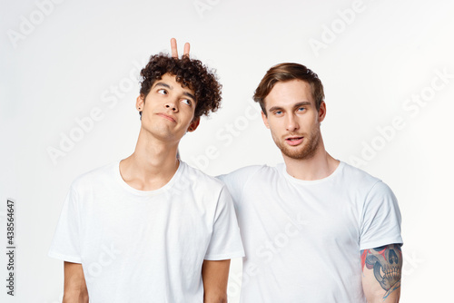 two men in white t-shirts gesturing with their hands Friendship Studio