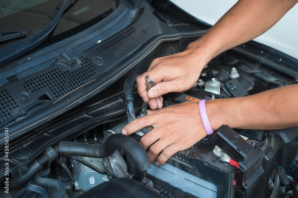 Male mechanic changing car battery ,Car service ,fitting a car battery with wrench