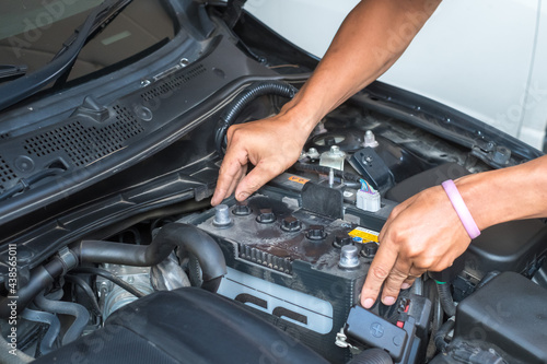 Male mechanic changing car battery ,Car service ,fitting a car battery with wrench