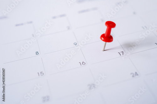 Selective focus. Picture of red pin embroidered on June 17 in the calendar. © PBXStudio