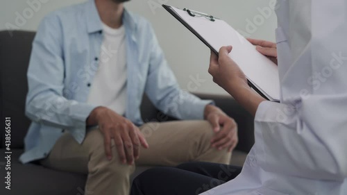 Man is discussing a problem of leran with a psychiatrist. Psychiatrist holds the patient's hand for encouragement and advice of method reduce of stress. Mental advisor concept. photo