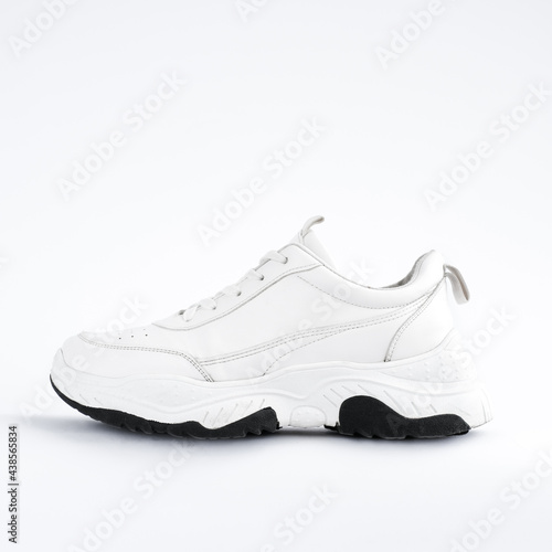 white sneaker on a light background. fashionable sports shoes with massive soles. 