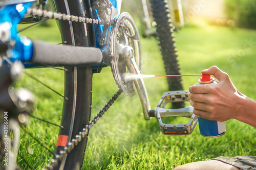 father and son maintain bike on a sunny summer day