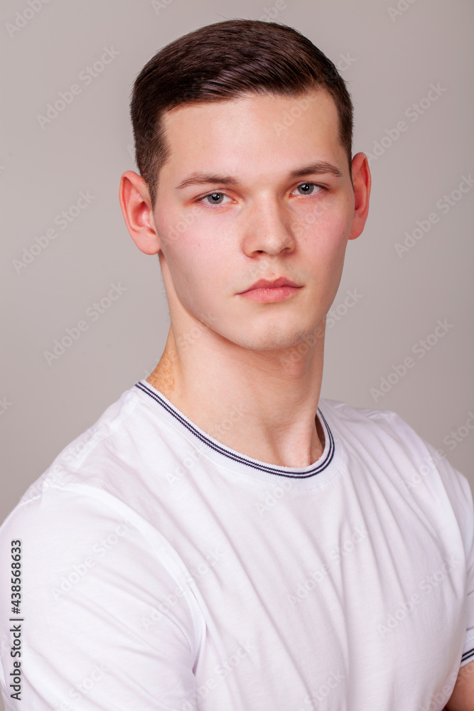Portrait of a young beautiful man posing on a background gray isolated Portrait of a young beautiful man posing on a background gray isolated