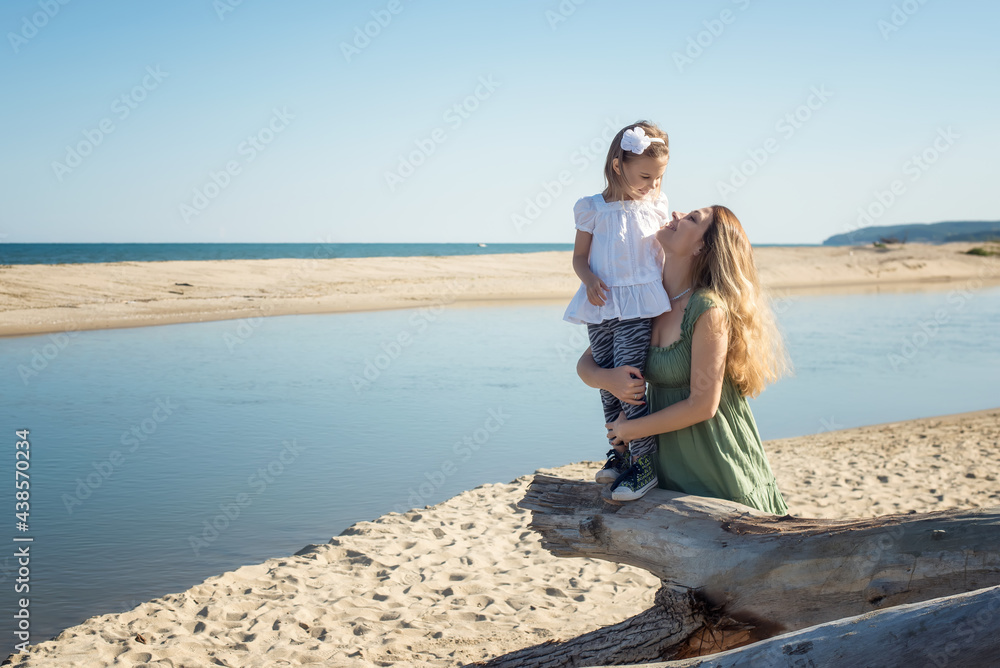 Mother and her daughter enjoy the sunny warm day at a sandy beach