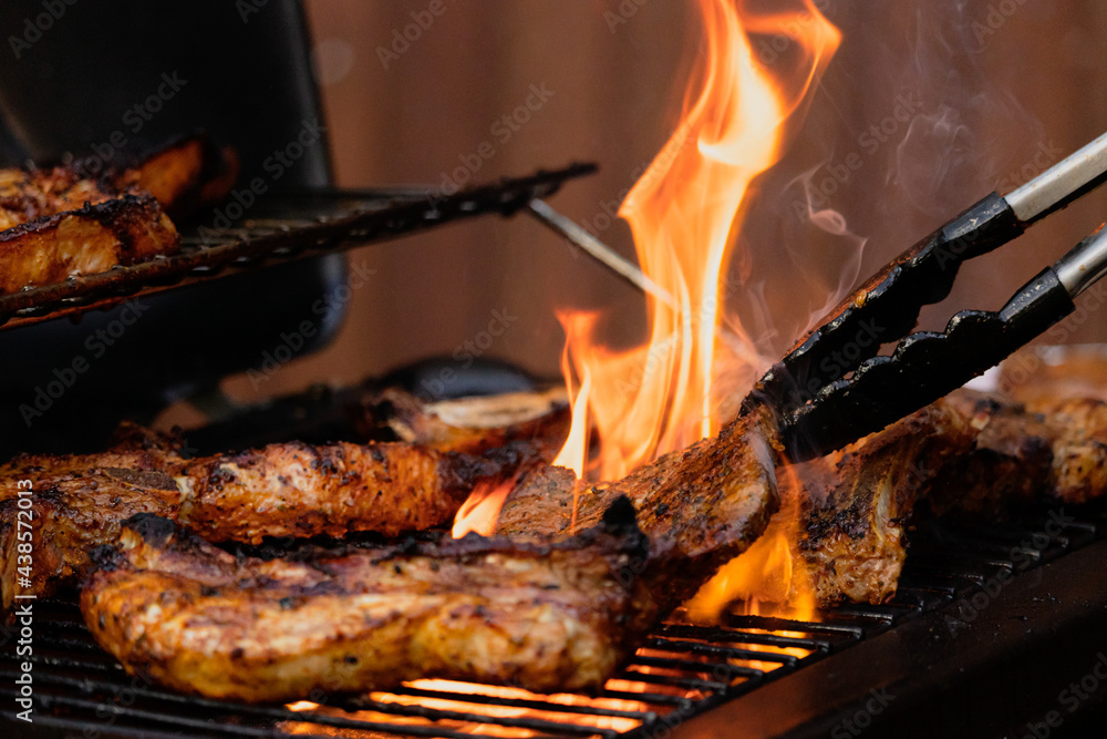bbq meat on a gas grill with flames